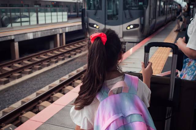 駅のホームでリュックを背負った女の子